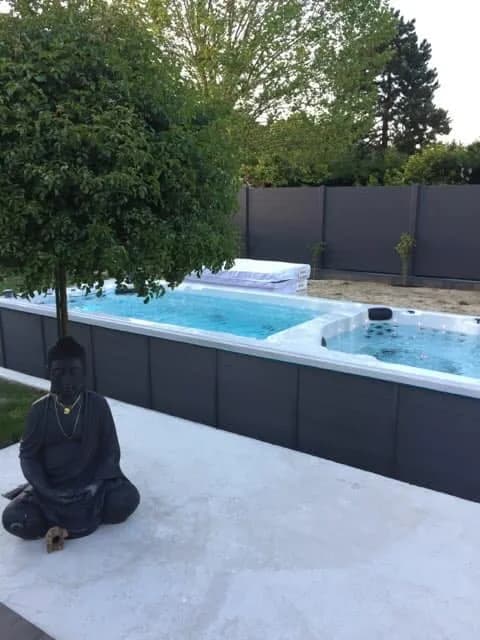 Installation d'un spa de nage Full option dans les Yvelines, sur une terrasse dallée au fond du jardin