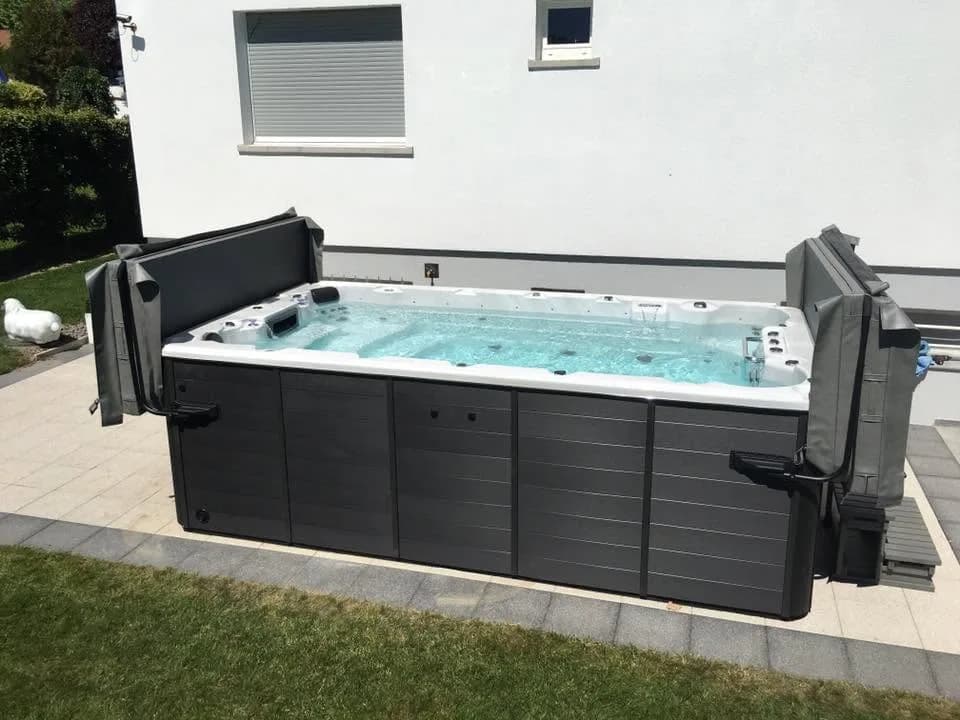 Installation d'un spa de nage Milan, sur une dalle, deux lève-couvertures