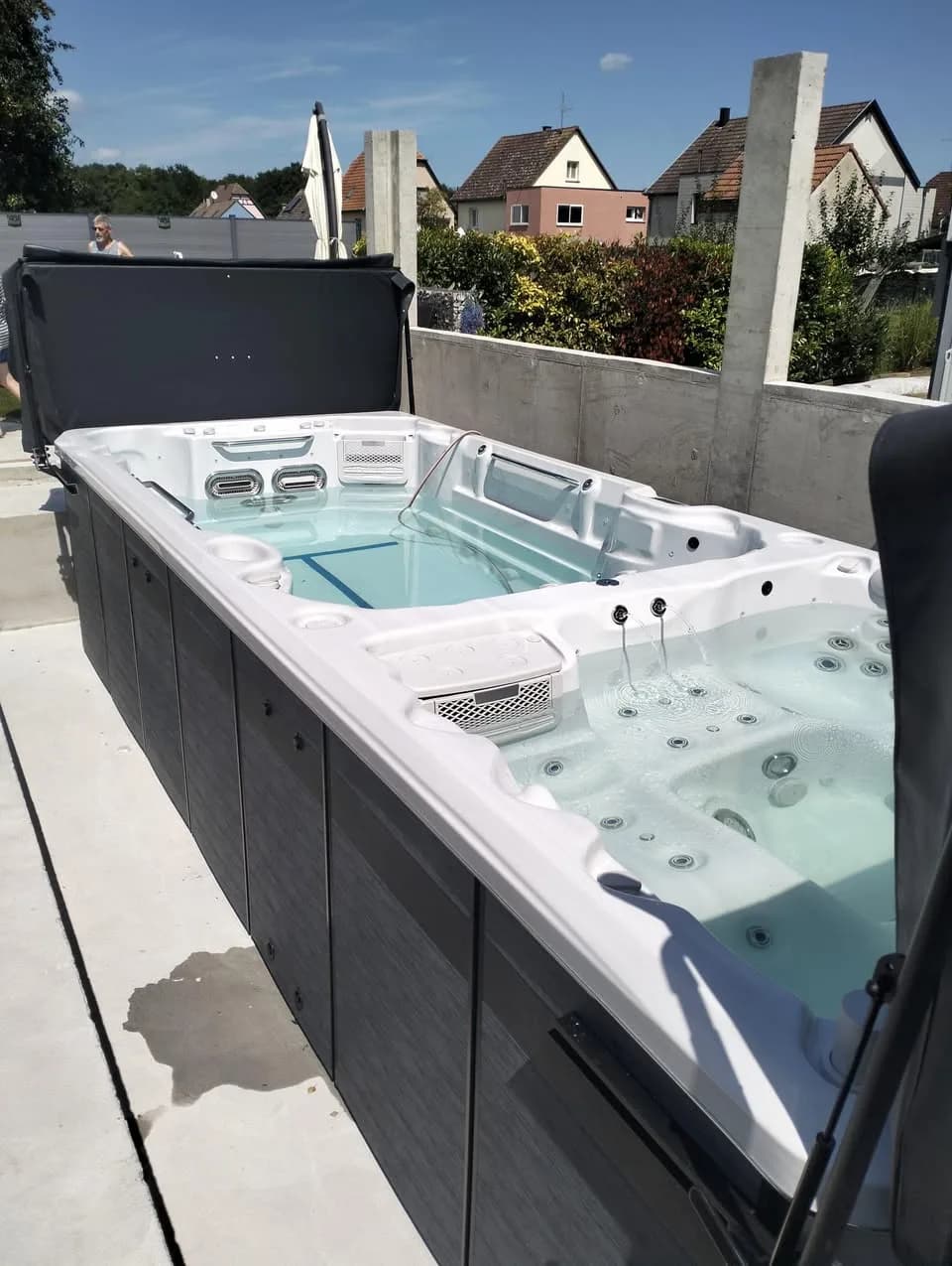 Installation d'un spa de nage Øslø 600 à Fortschwihr, sur une terrasse béton entre des murs