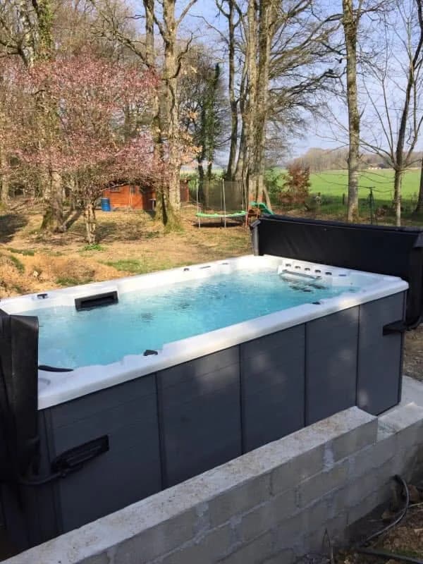 Installation d'un spa de nage Waterloo 390 dans le Loiret, dans un jardin arboré