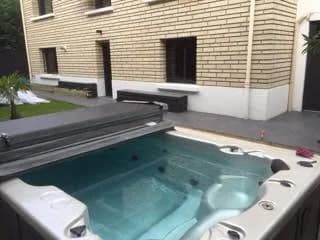 Installation d'un spa de nage Waterloo 390 Full option en Seine-et-Marne, encastré dans une terrasse devant la maison