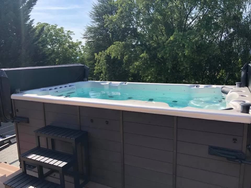 Installation d'un spa de nage Waterloo 390 Full option, sur une terrasse suspendue, marchepied