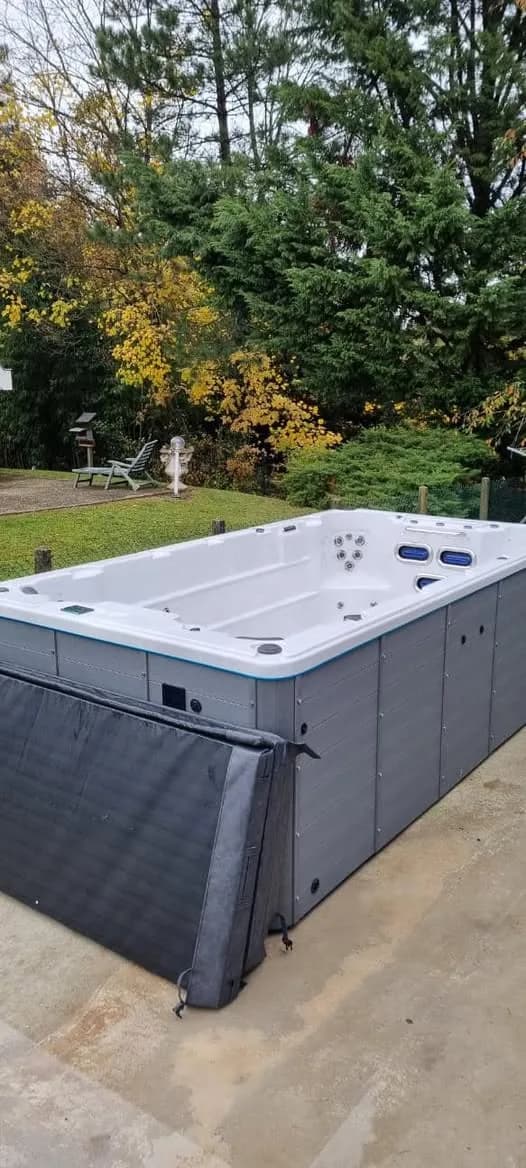 Installation d'un spa de nage Waterloo 421 Full option à Cernay, sur une dalle au fond d'un jardin