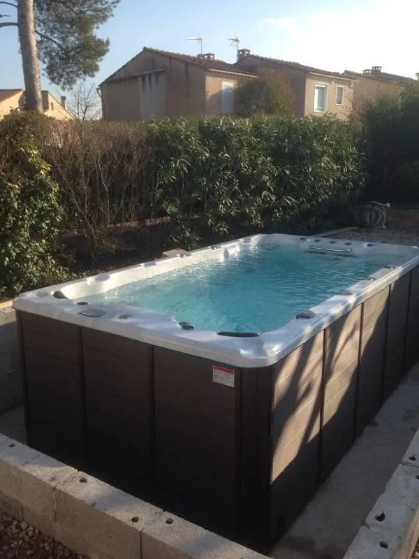 Installation d'un spa de nage Waterloo 421 Full option, dans un jardin le long d'une haie