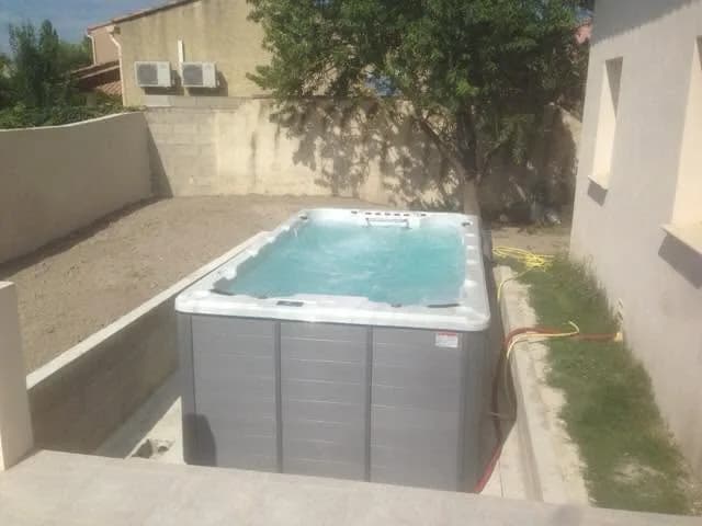 Installation d'un spa de nage Waterloo 501 à Bordeaux, en encastrement le long d'une dalle en béton