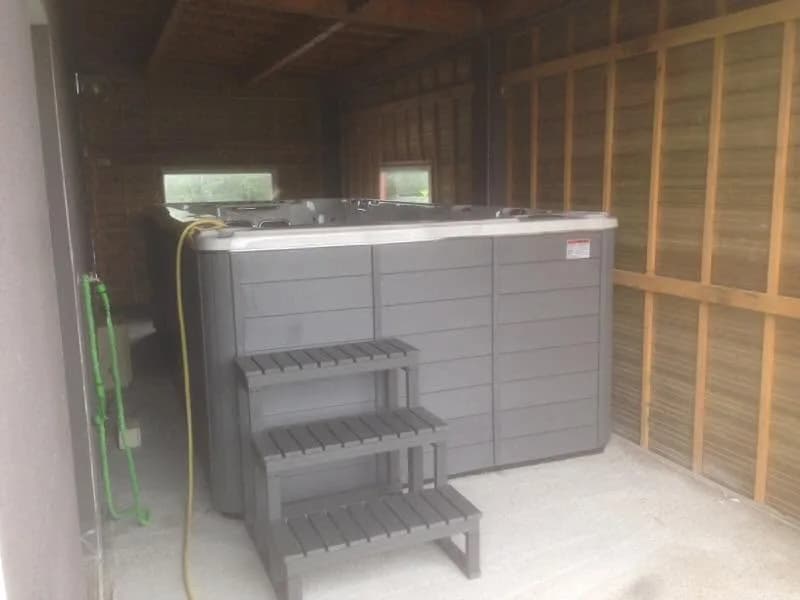 Installation d'un spa de nage Waterloo 501 dans le Morbihan, dans un abri en bois, marchepied