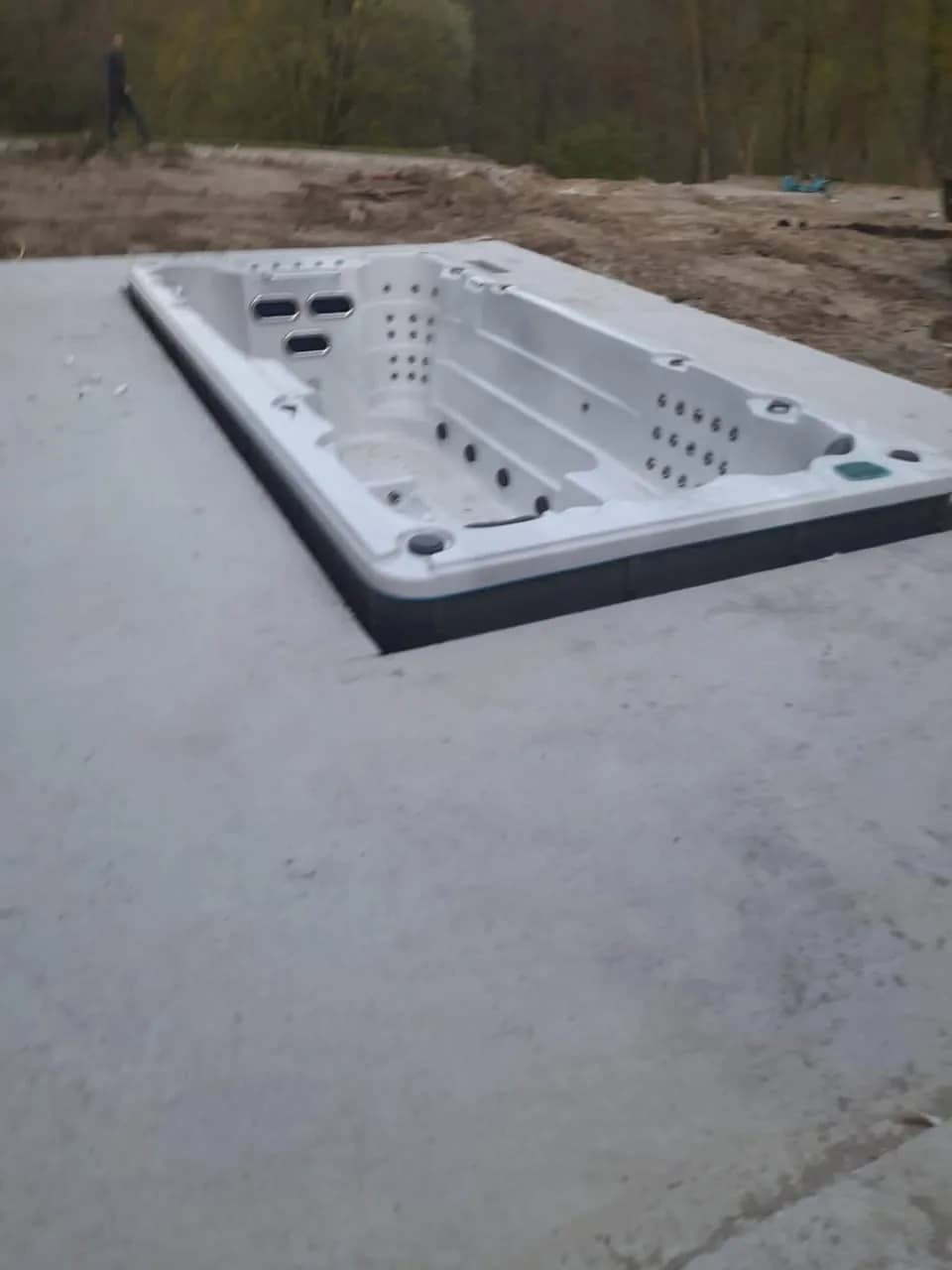 Installation d'un spa de nage Waterloo 501 en Belgique, encastré dans une dalle en béton