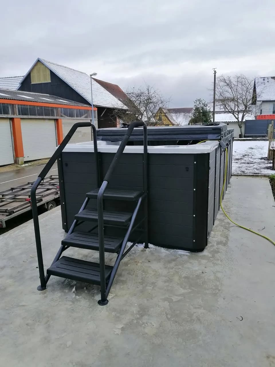 Installation d'un spa de nage Waterloo 501 à Folgensbourg, sur une dalle en béton, échelle d'accès