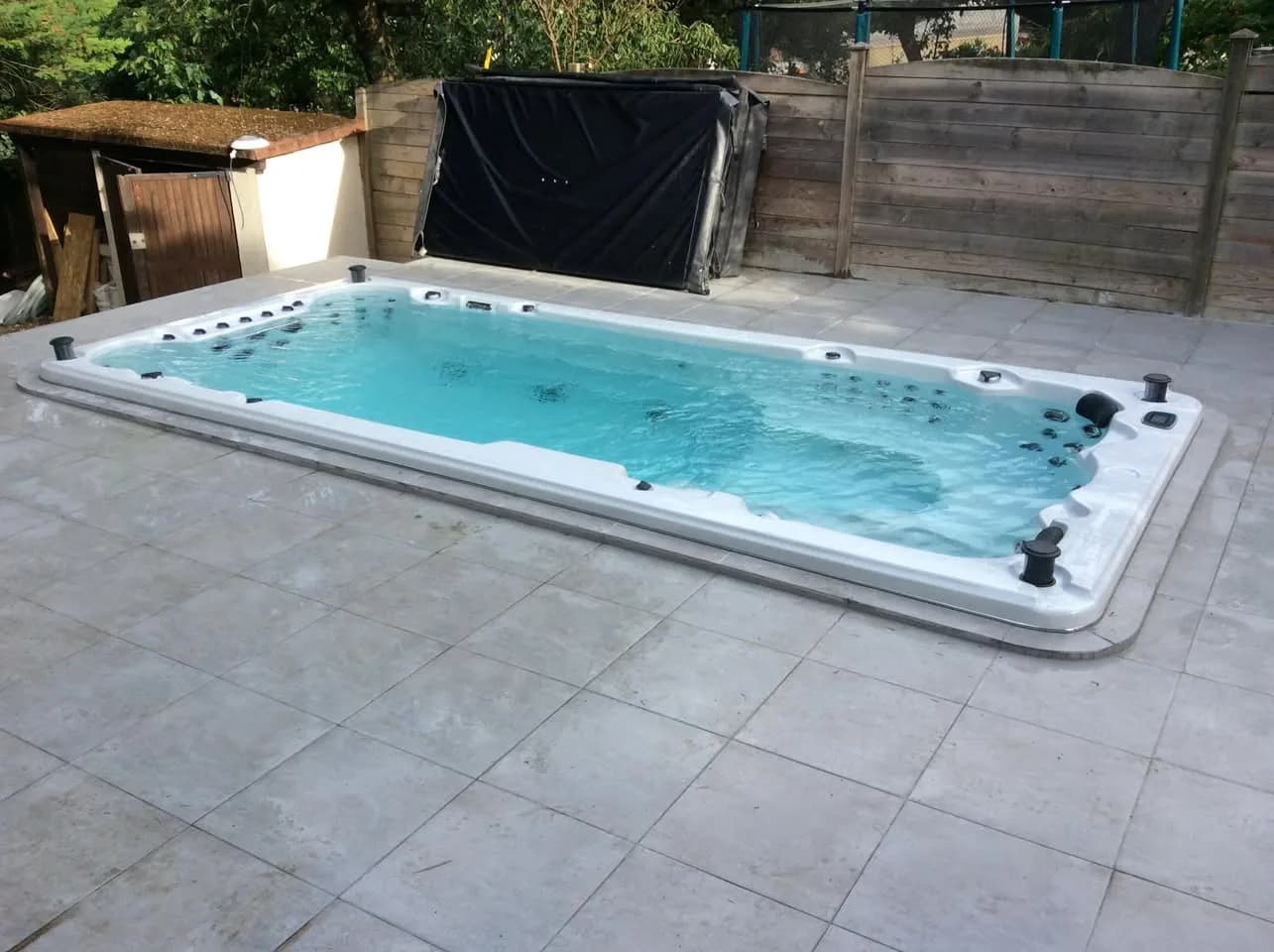 Installation d'un spa de nage Waterloo 501 Full option à Paris, encastré dans une terrasse carrelée