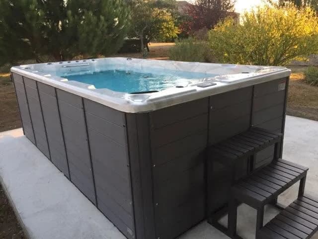 Installation d'un spa de nage Waterloo 501 à Gémenos, sur une dalle claire, marchepied
