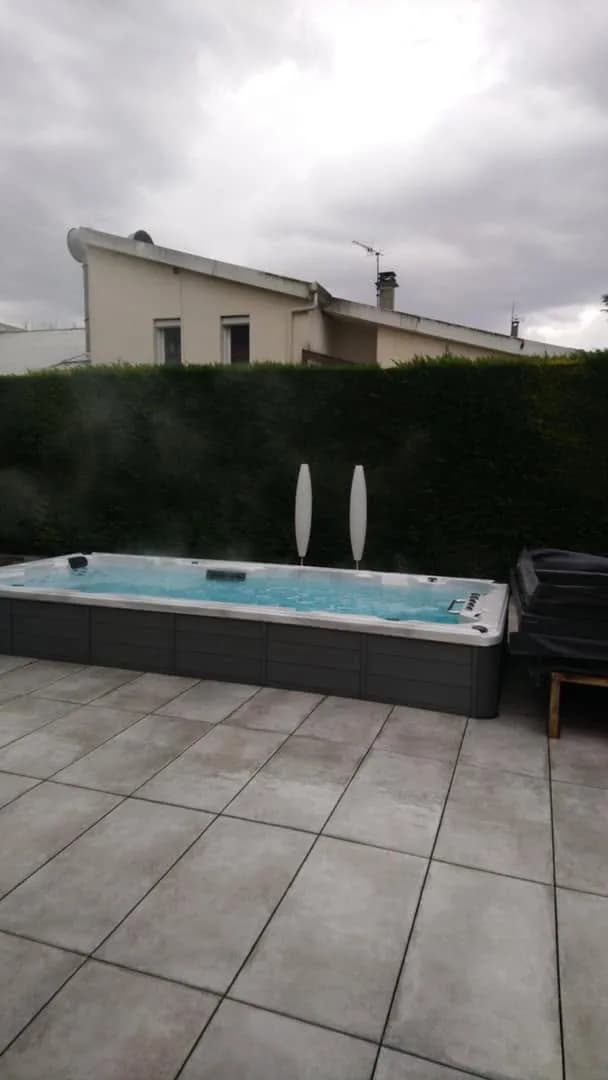 Installation d'un spa de nage Waterloo 501 à Gray, encastré dans une terrasse dallée