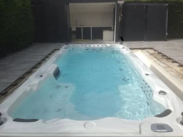 Installation d'un spa de nage Waterloo 501 à Hagetmau, posé sur une terrasse dallée, mis en eau