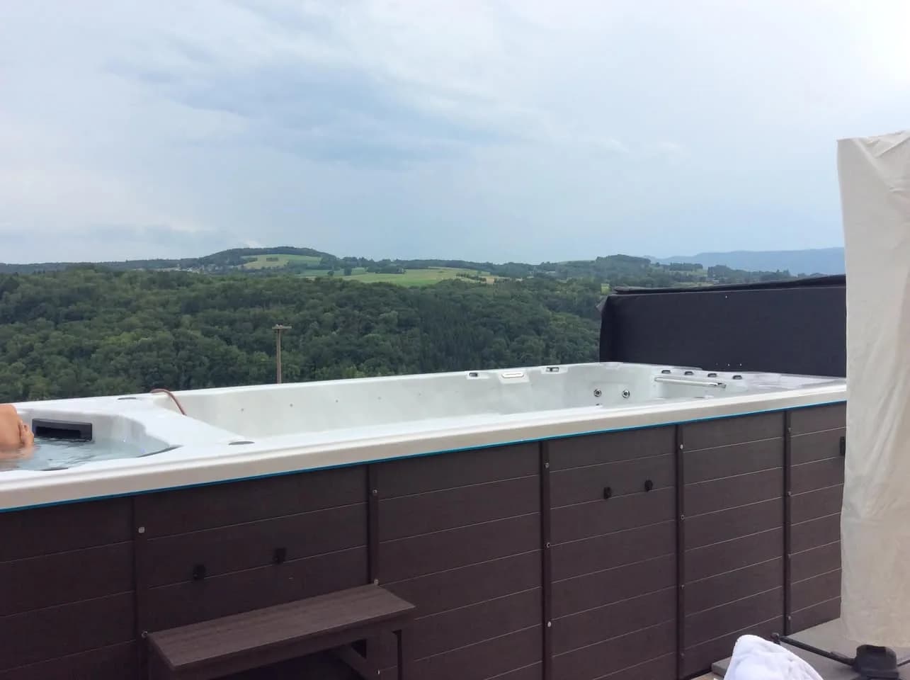 Installation d'un spa de nage Waterloo 594 Full option à Frangy, sur une terrasse en bois face à la vallée
