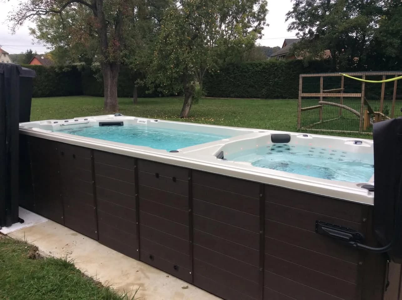 Installation d'un spa de nage, sur une dalle en bordure de pelouse