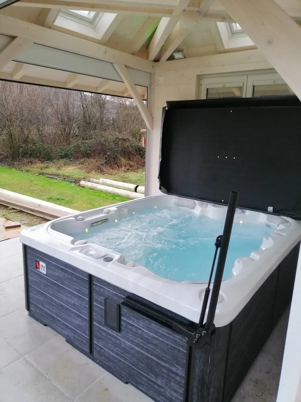 Installation d'un spa Drøbak dans le Bas-Rhin, sous un auvent, lève-couverture