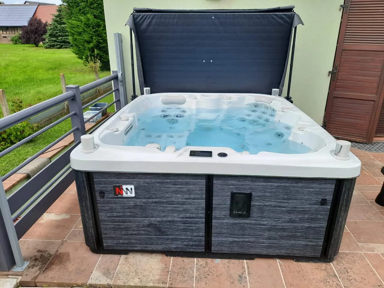 Installation d'un spa Drøbak Full option à Battenheim, sur un dallage en terre cuite, lève-couverture