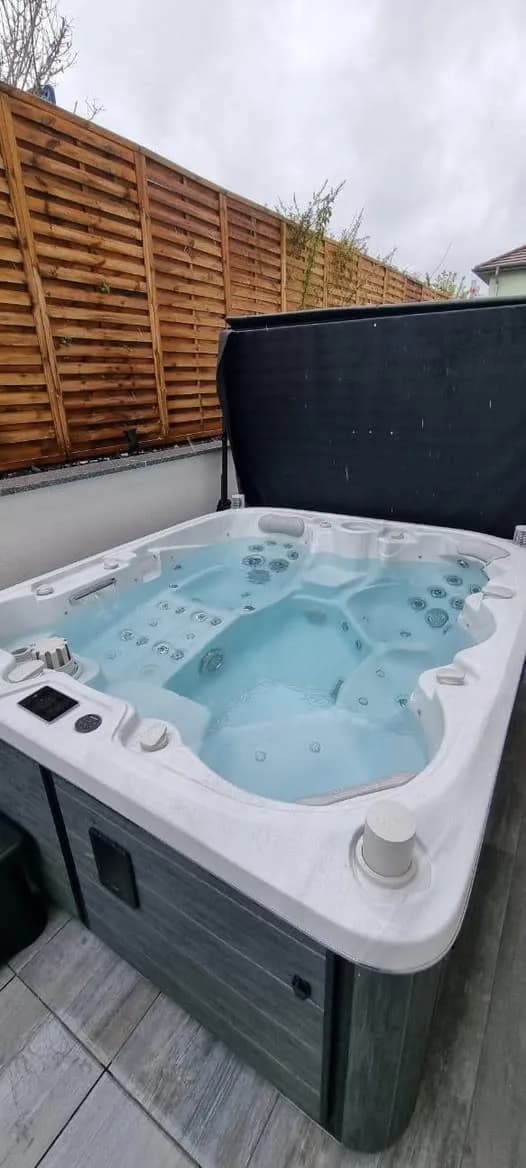 Installation d'un spa Drøbak Full option à Flaxlanden, sur une terrasse en lames, palissade en bois