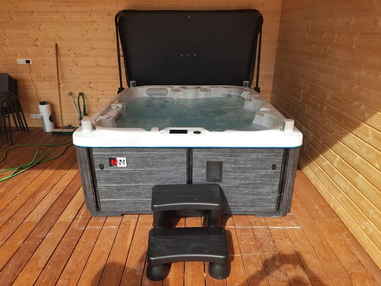 Installation d'un spa Drøbak Full option à Zaessingue, sous un abri en bois, lève-couverture et marchepied