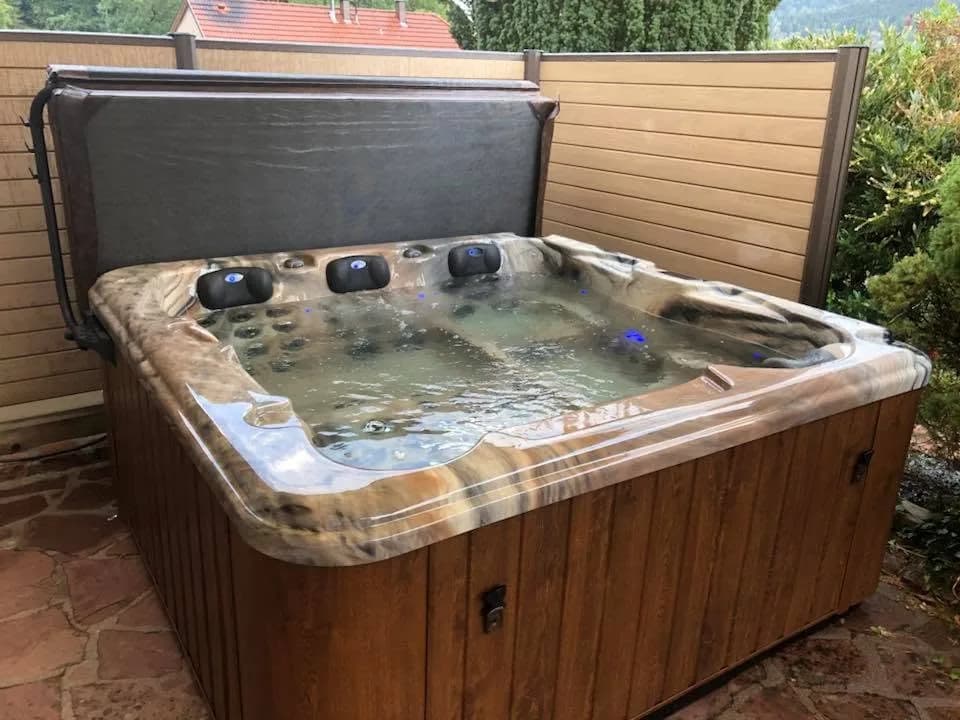 Installation d'un spa Halifax à Ranspach, contre une palissade, cuve marbrée