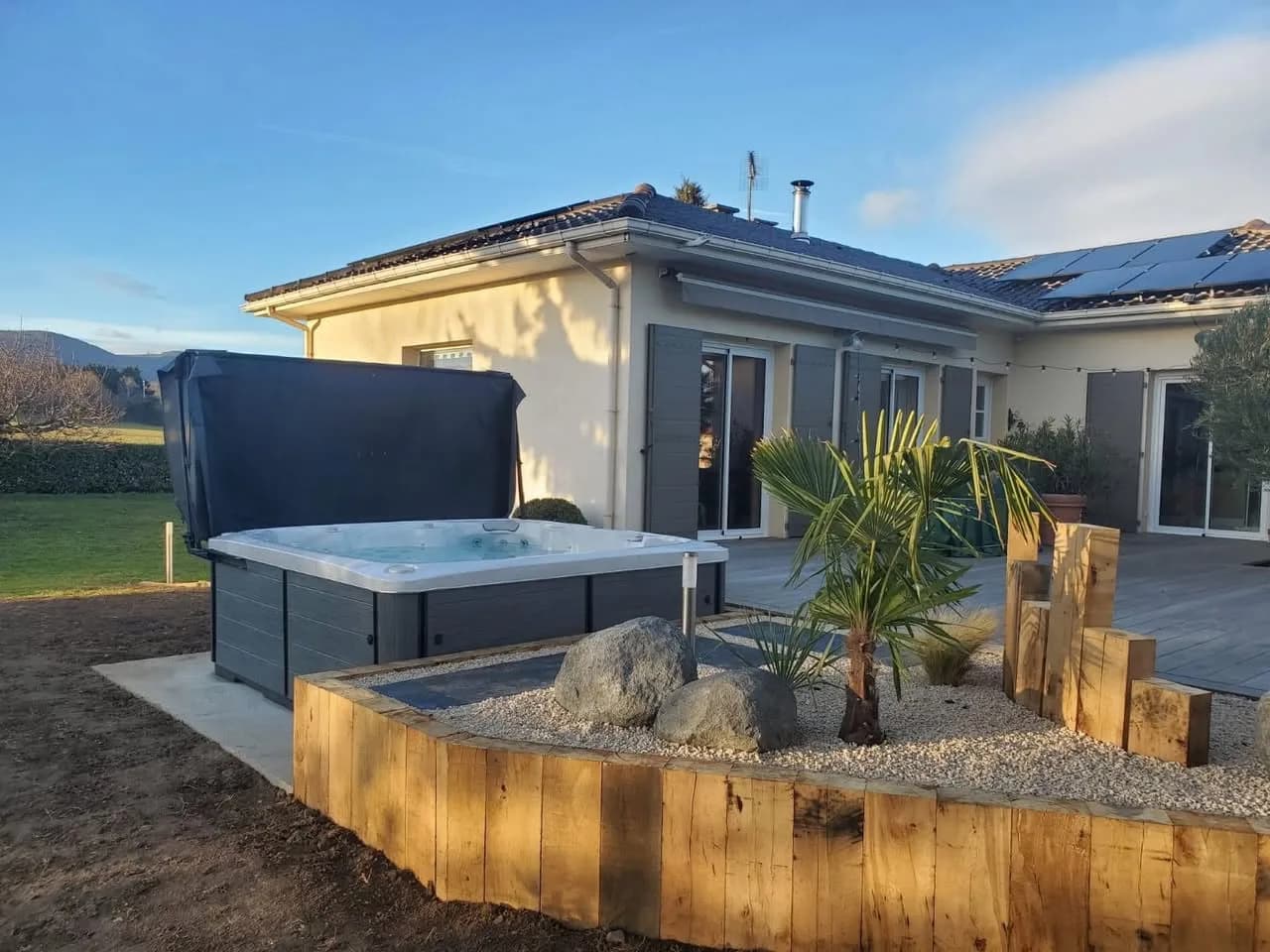 Installation d'un spa Hølen dans la Loire, sur une terrasse en lames, jardin paysager