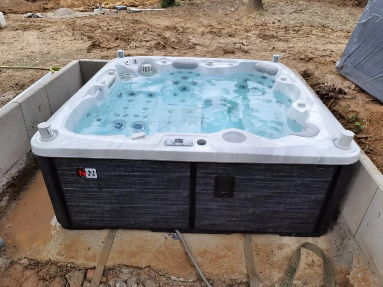 Installation d'un spa Hølen Full option à Zimmersheim, dans un coffrage en béton près d'une piscine