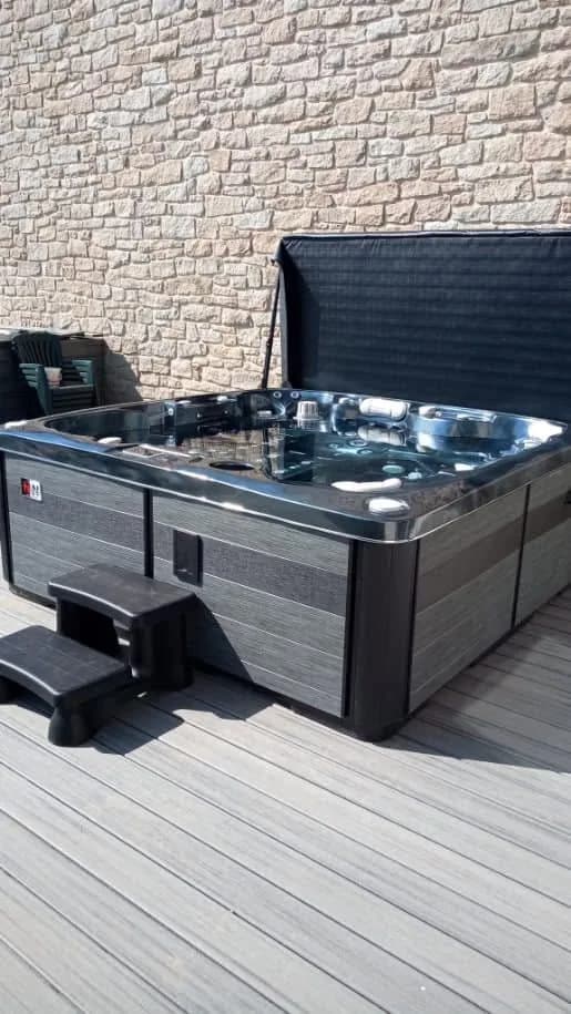 Installation d'un spa Hølen Full option, sur une terrasse en lames, marchepied