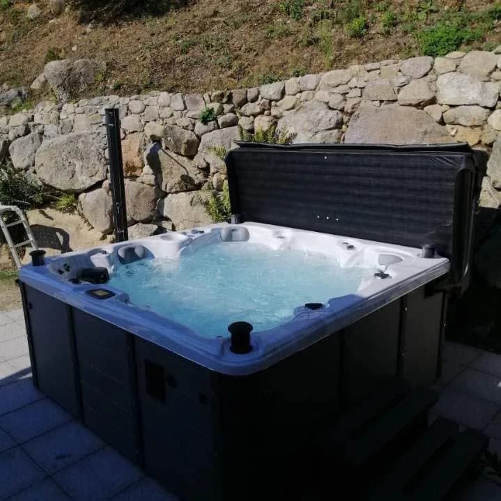 Installation d'un spa Kendrick Duel Full option à Fellering, au pied d'un mur en pierres, vue sur la vallée