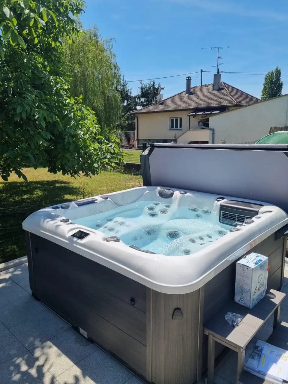 Installation d'un spa Marina à Habsheim, dans un jardin, couverture relevée