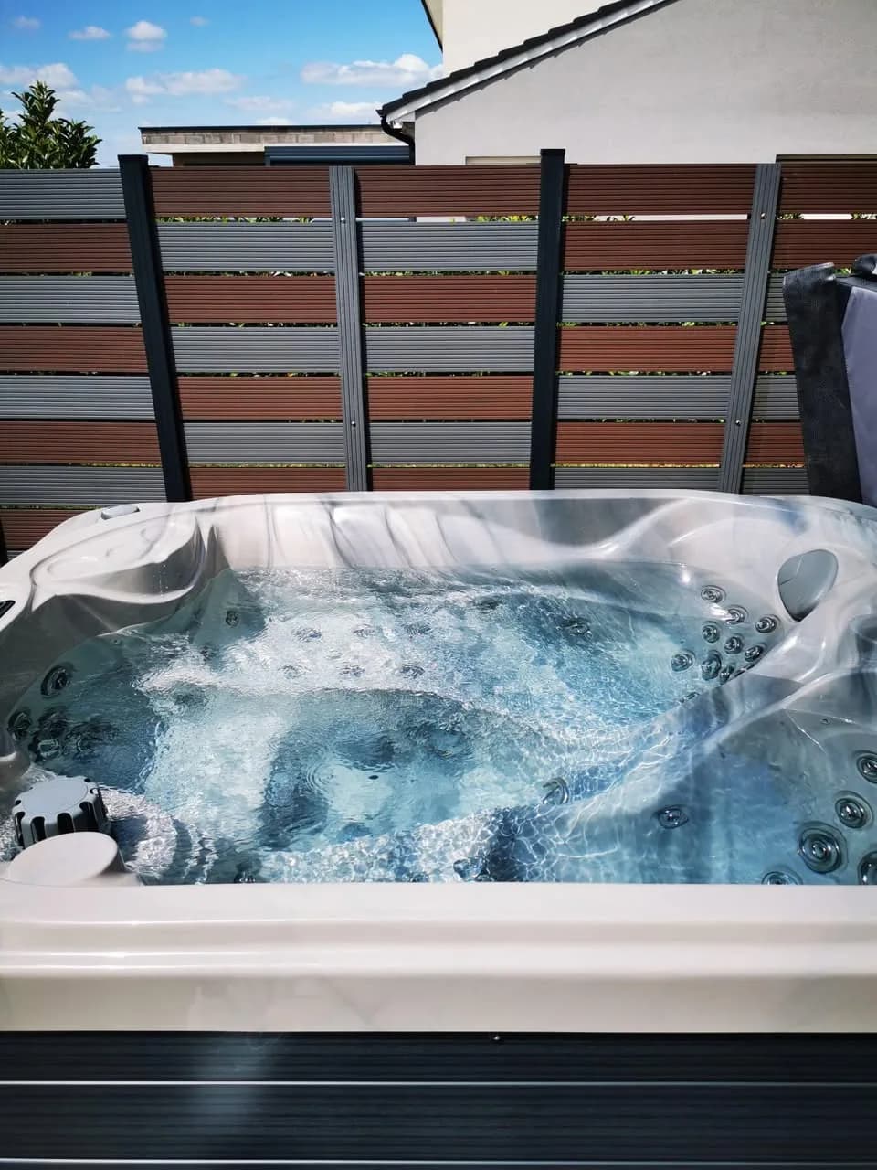 Installation d'un spa Mercury à Chieulles, sur une terrasse devant un brise-vue