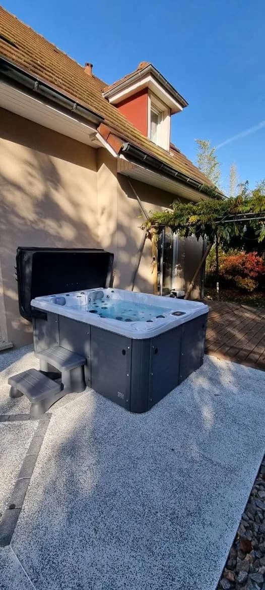 Installation d'un spa Montana à Altkirch, sur une dalle près de la maison, lève-couverture