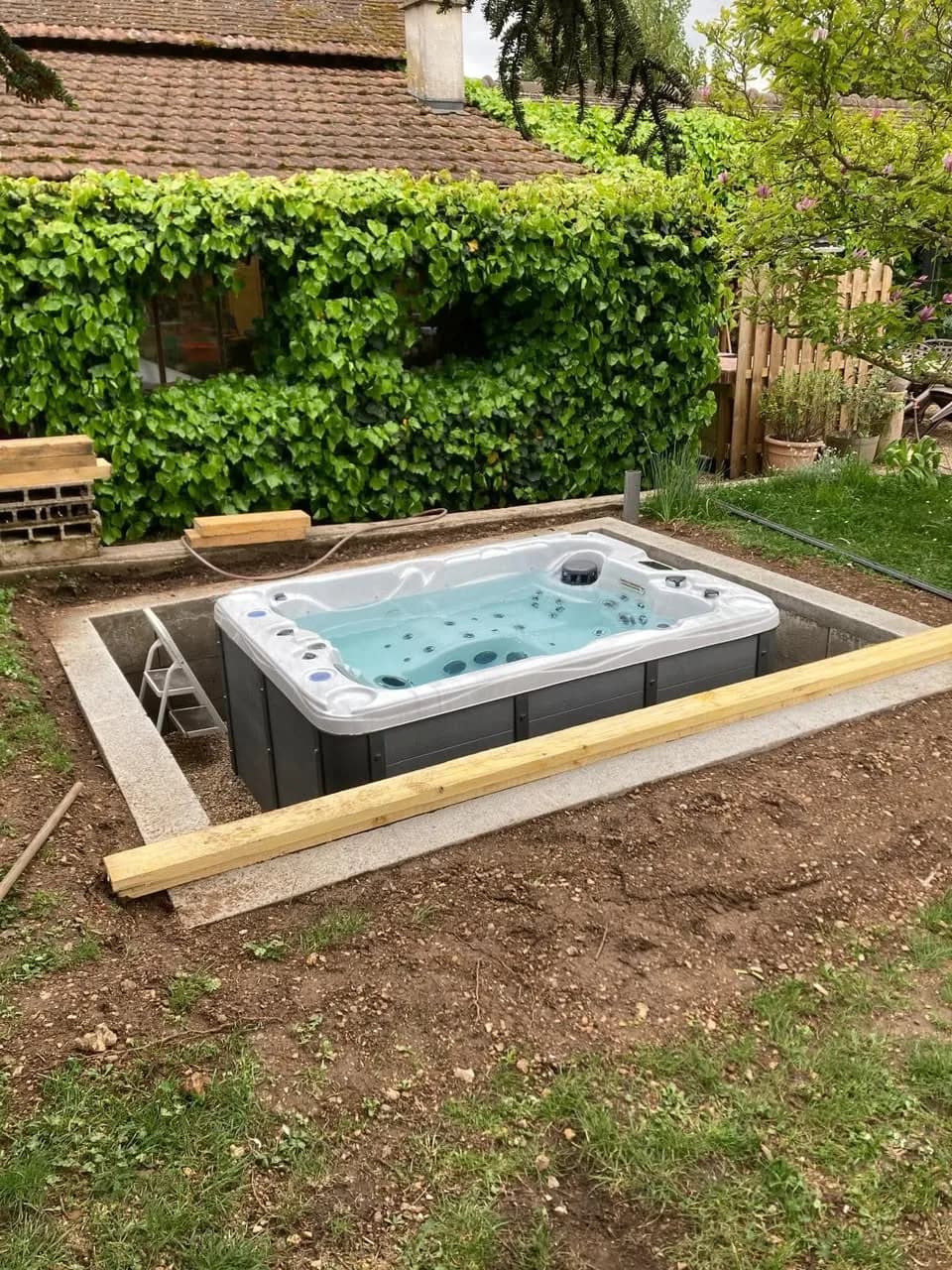 Installation d'un spa Montana à Asnières-sur-Iton, encastré dans le sol au pied d'une haie