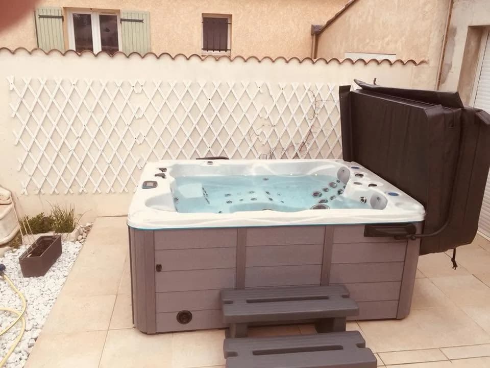 Installation d'un spa Montana dans la Drôme, sur une terrasse carrelée devant un treillis blanc