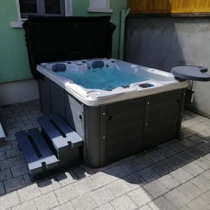 Installation d'un spa Montana dans le Haut-Rhin, sur une cour pavée, avec marchepied