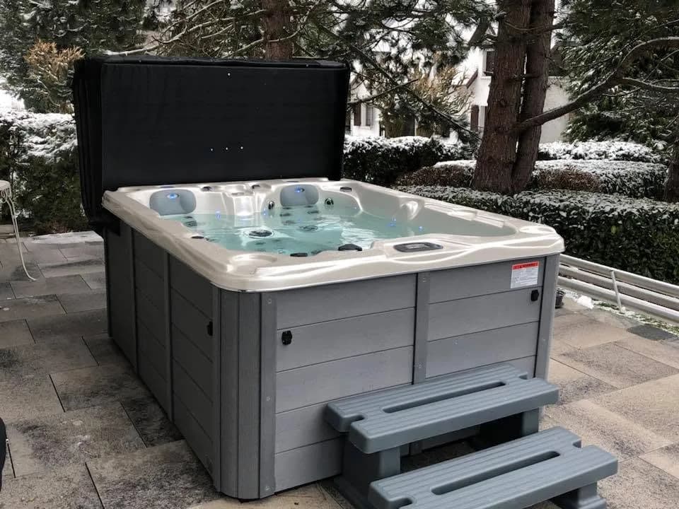 Installation d'un spa Montana à Dasle, sur une terrasse dallée, lève-couverture et marchepied