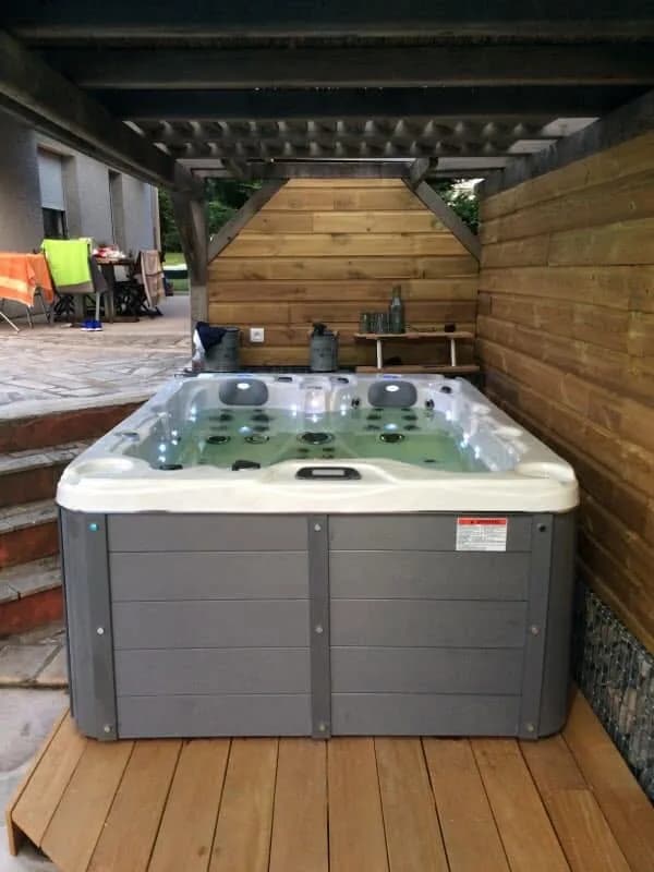 Installation d'un spa Montana en Haute-Loire, sur un plancher en bois sous un abri