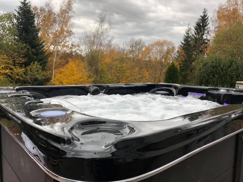 Installation d'un spa Montana à Épinal, dans un jardin arboré, cuve noire