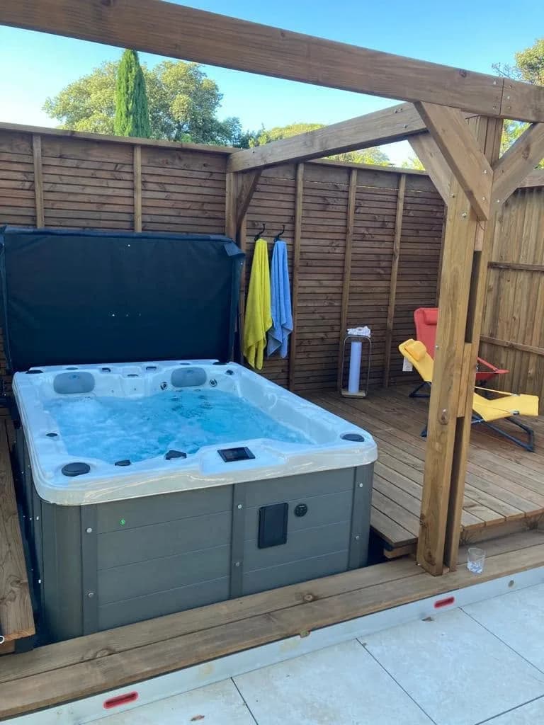 Installation d'un spa Montana Full option à Avignon, sous une pergola en bois devant une palissade