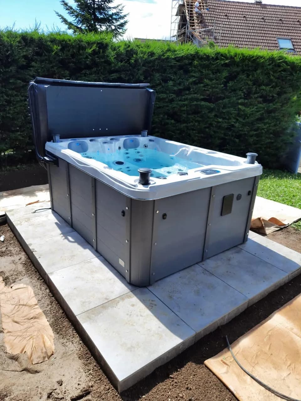 Installation d'un spa Montana Full option à Battenheim, sur une dalle devant une haie