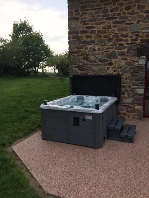 Installation d'un spa Montana Full option en Ille-et-Vilaine, sur une dalle contre un mur en pierre