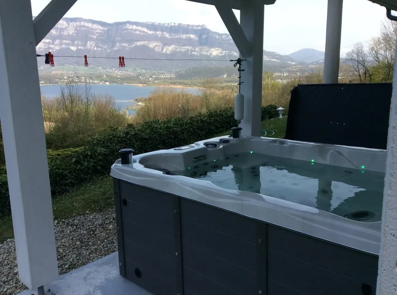 Installation d'un spa Montana Full option en Savoie, sous un auvent, vue sur le lac du Bourget