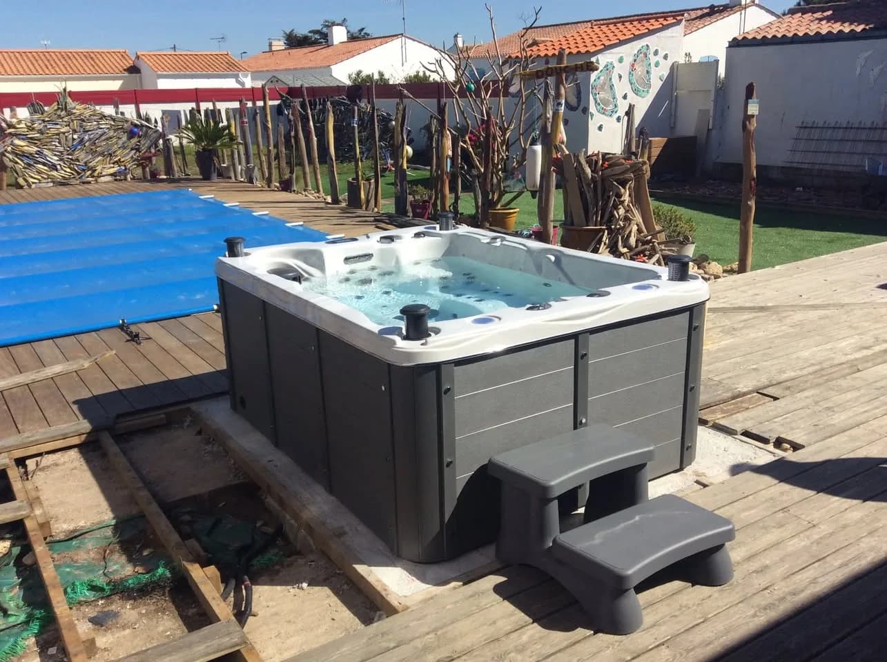 Installation d'un spa Montana Full option à Île de Noirmoutier, sur une terrasse en bois au bord d'une piscine