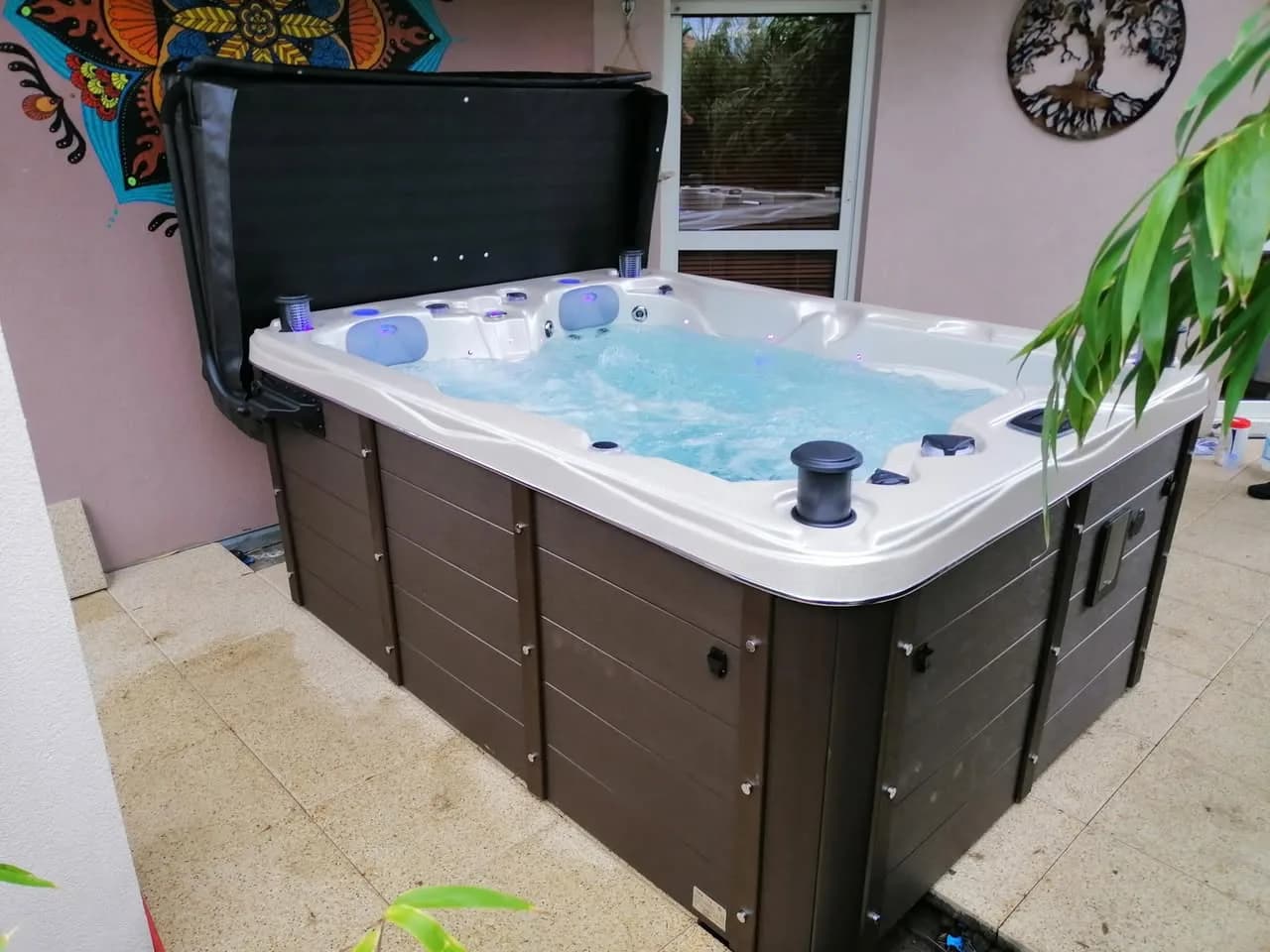 Installation d'un spa Montana Full option à Ungersheim, sur une terrasse carrelée, lève-couverture