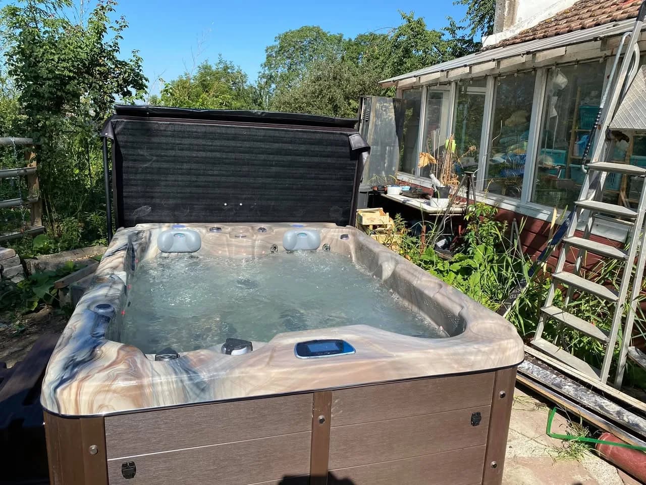 Installation d'un spa Montana à Krautergersheim, dans une cour, avec lève-couverture
