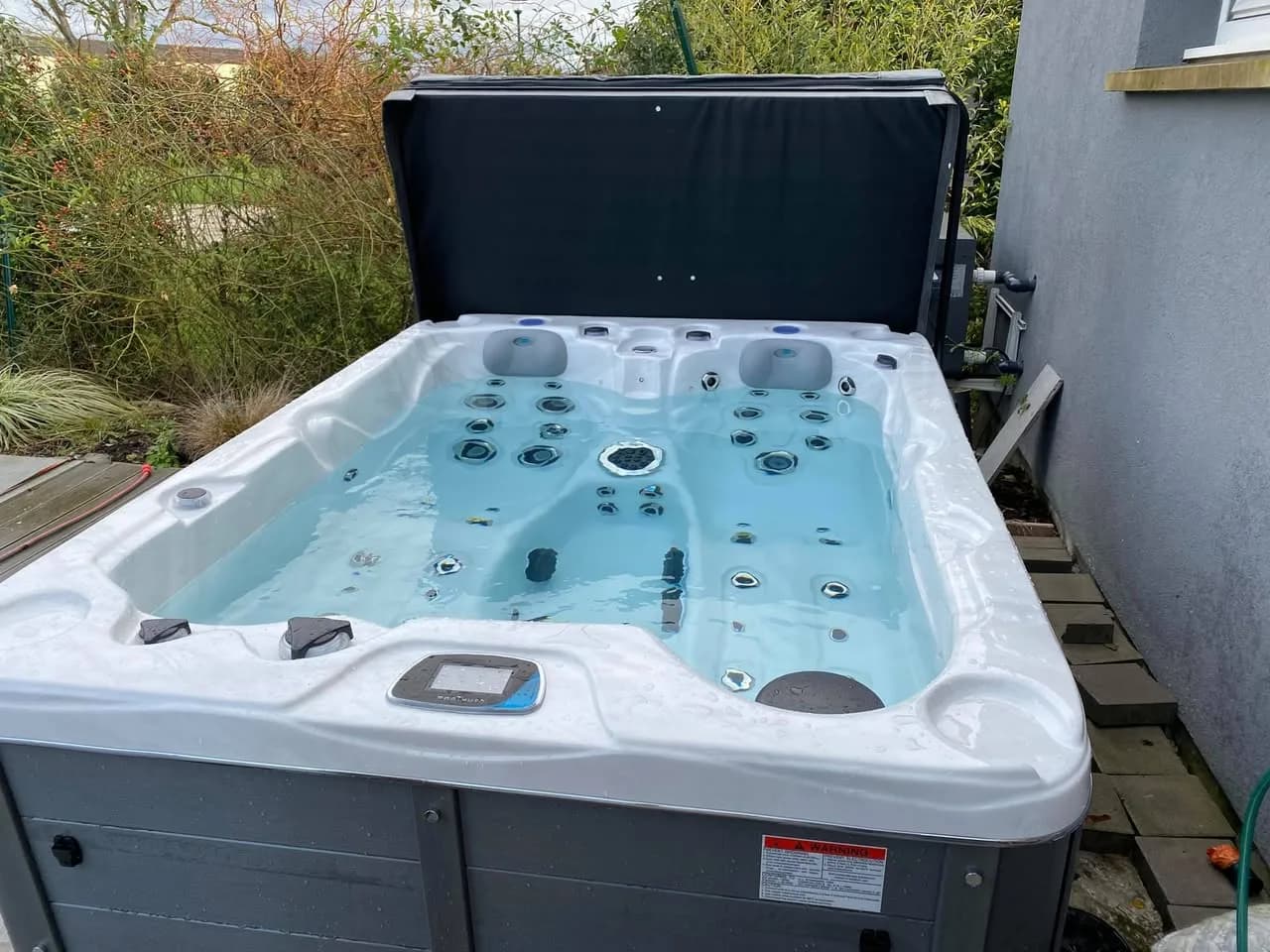 Installation d'un spa Montana à Oberschaeffolsheim, sur une terrasse, avec lève-couverture