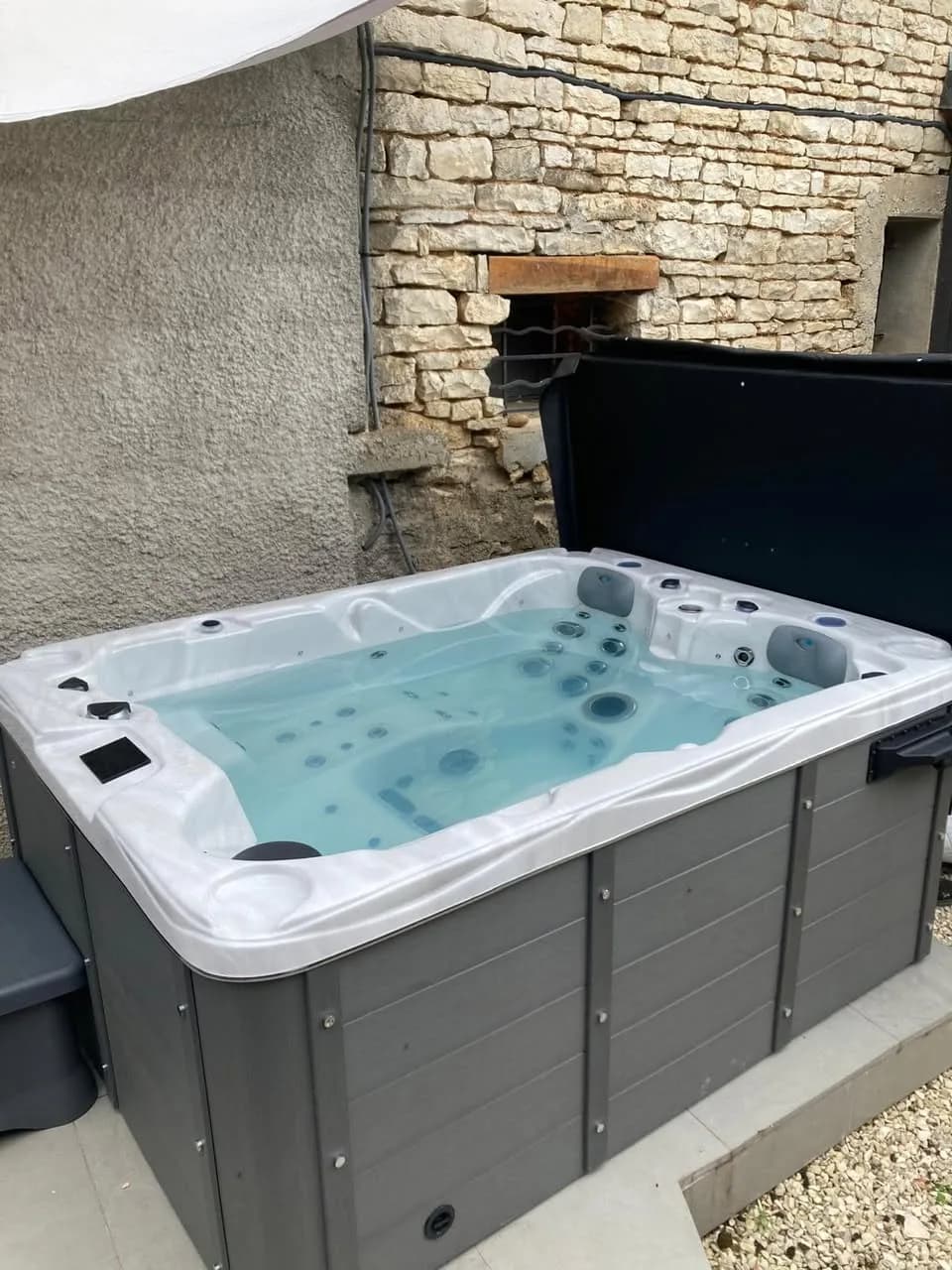 Installation d'un spa Montana à Poilly-sur-Serein, contre un mur en pierre