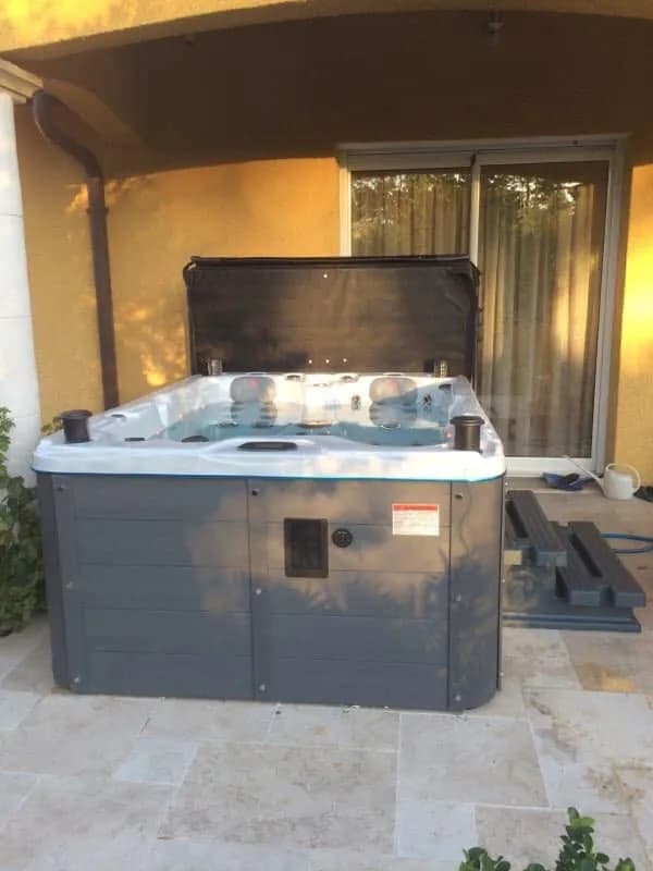 Installation d'un spa Montana à Saint-Maurice-de-Gourdans, sous un auvent contre la maison, avec marchepied