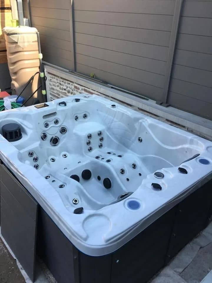 Installation d'un spa Montana à Toulouse, devant une palissade