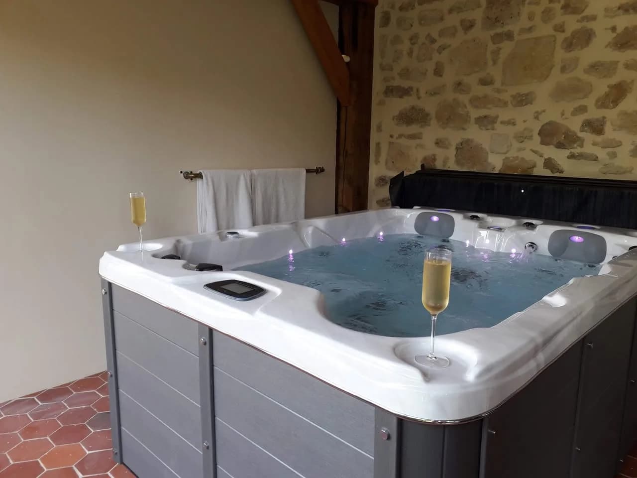 Installation d'un spa Montana à Vendresse-Beaulne, contre un mur de pierre, sol en tomettes