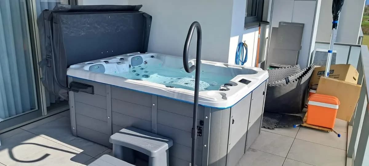 Installation d'un spa Montana à Village-Neuf, sur une terrasse à garde-corps vitré, barre d'appui