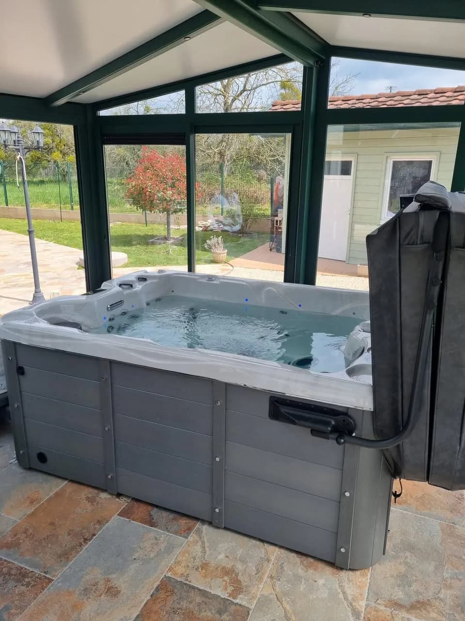Installation d'un spa Montana à Virecourt, dans une véranda vitrée, sol en ardoise